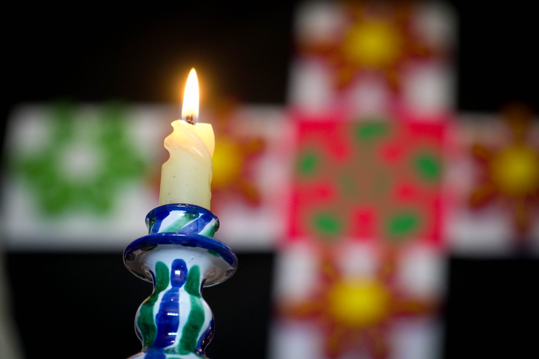 Vela encendida en un soporte de cerámica granadina